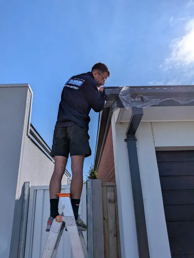 Roof plumber working on gutter in Kew
